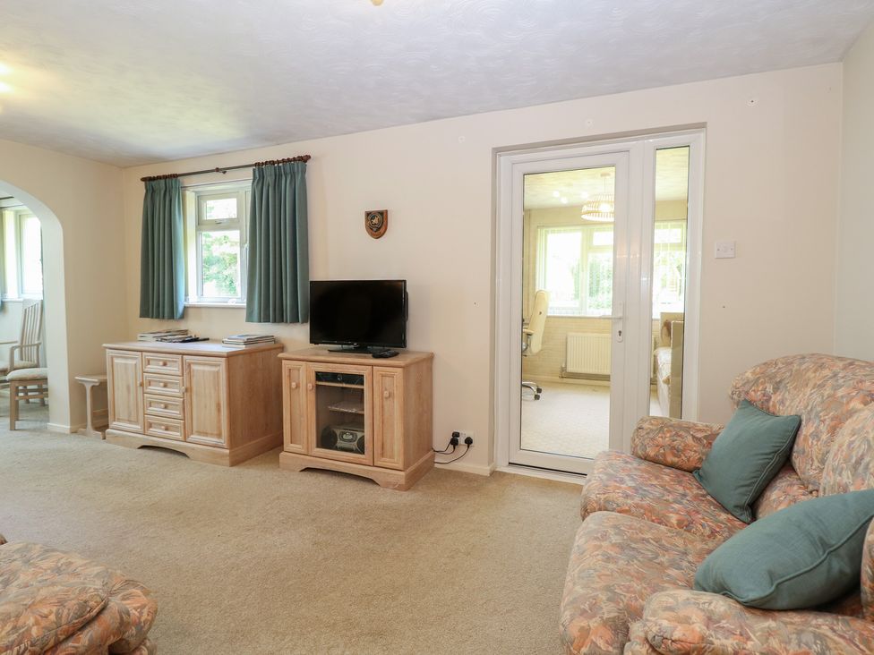 A living room with a television and a cabinet at 51 Colin McLean Road Dereham