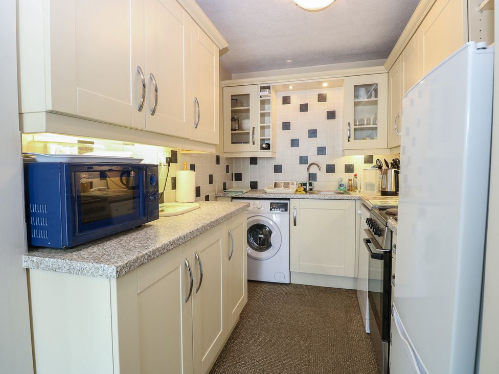 A kitchen with a washing machine and microwave at 51 Colin McLean Road Dereham