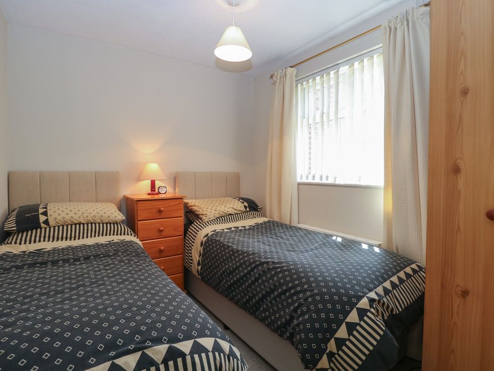 A bedroom with two single beds and a bedside table at 51 Colin McLean Road Dereham