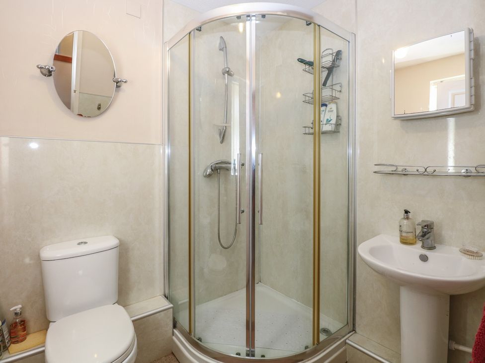 A bathroom featuring a shower, toilet, sink, and mirror at 51 Colin McLean Road Dereham