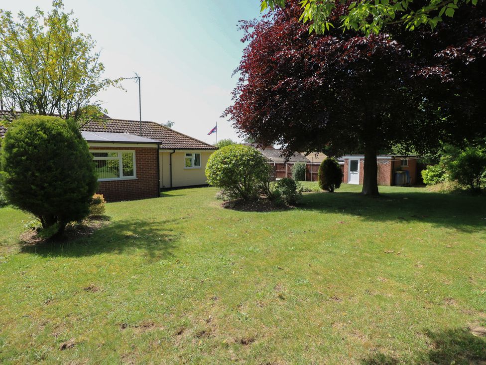 A garden with a house and trees at 51 Colin McLean Road Dereham