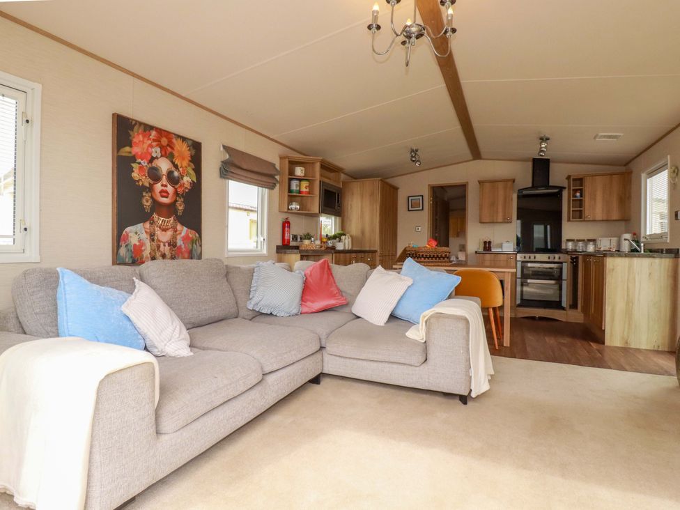 A living room with a sofa and kitchen area at CC2