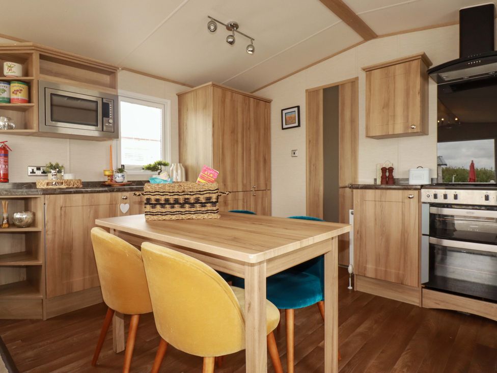 A kitchen with a microwave and dining table at CC2