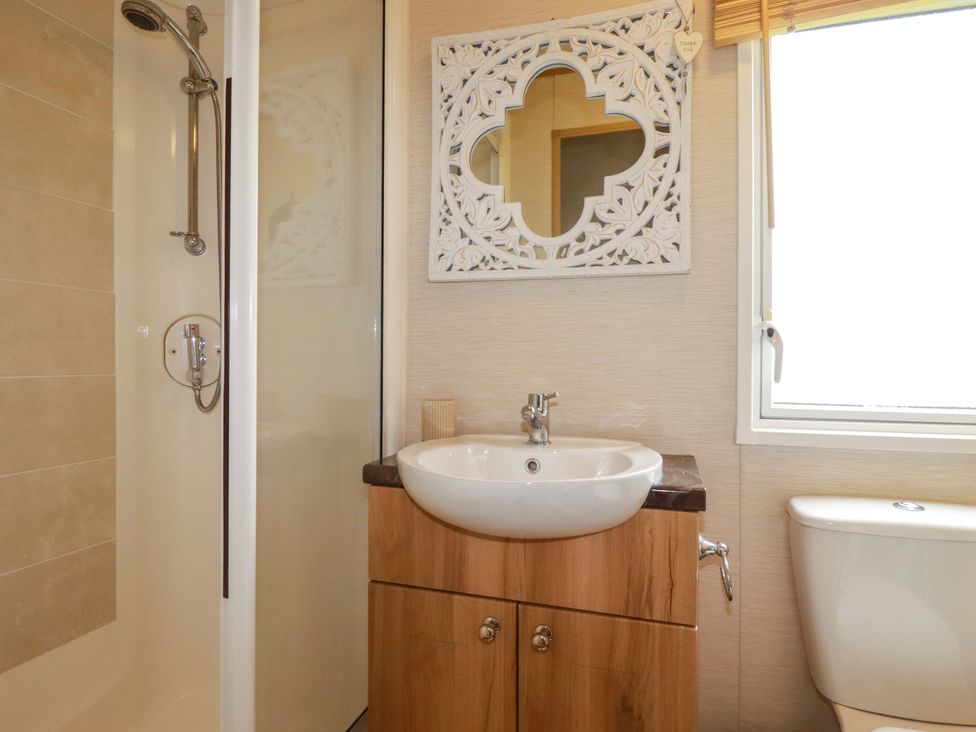 A bathroom featuring a shower, sink, and toilet at CC2