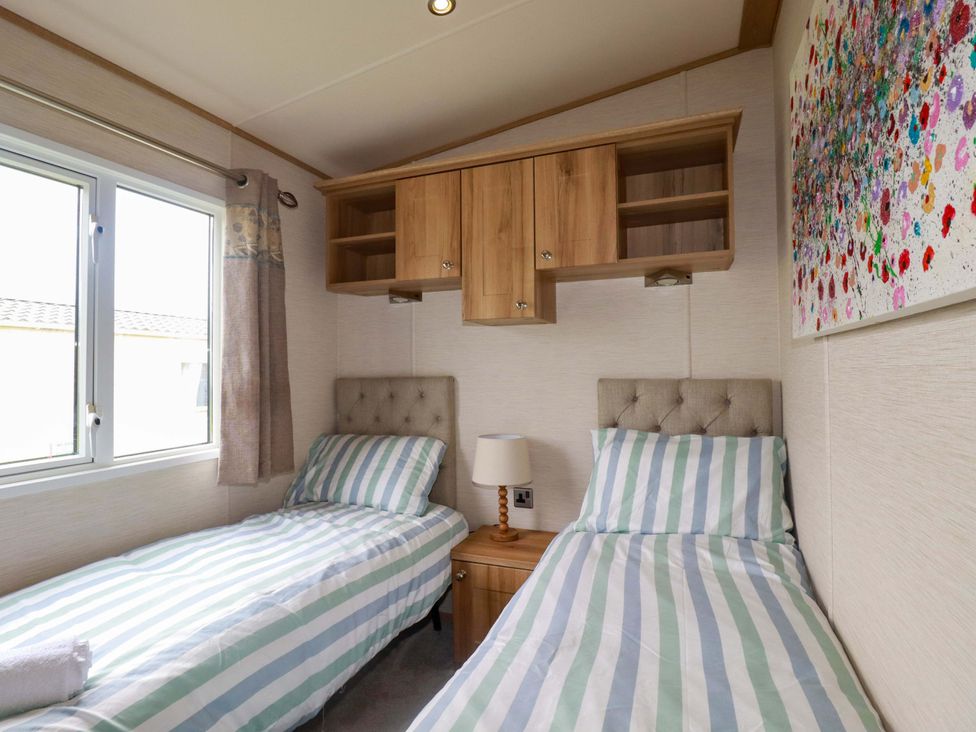 A bedroom with two single beds and artwork at CC2