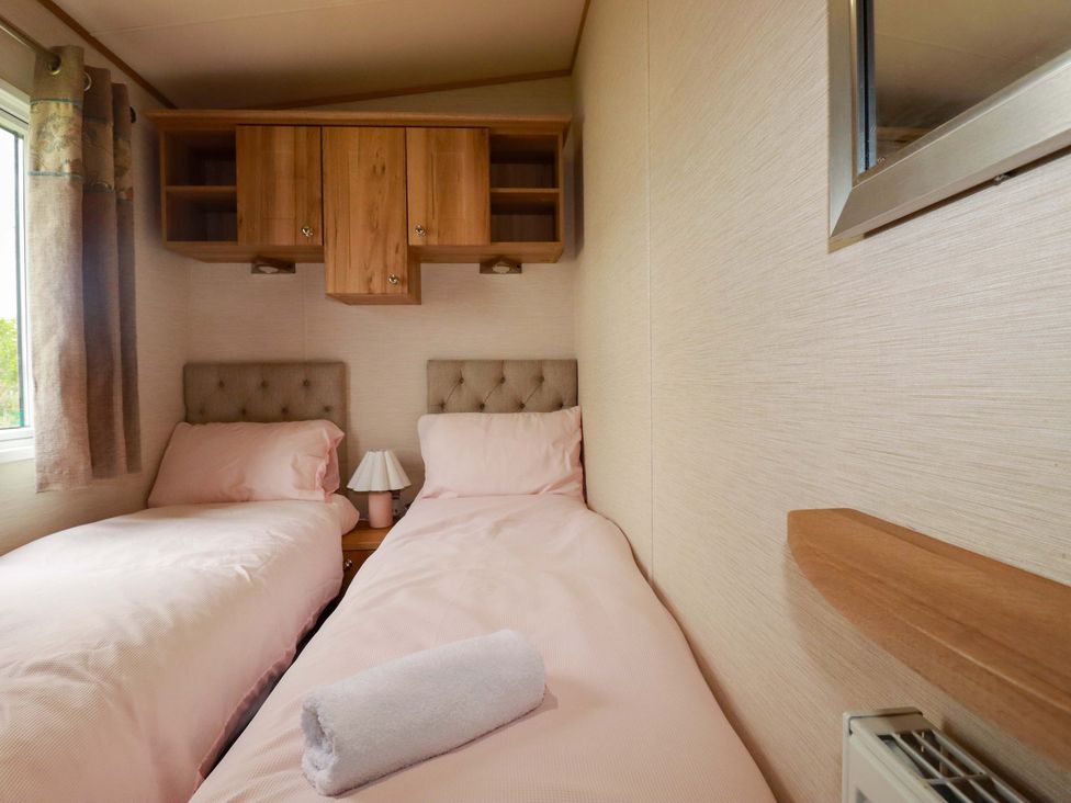 A bedroom with two beds and a bedside table at CC2