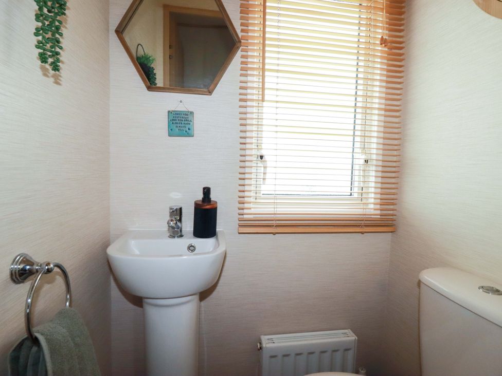 A bathroom with a sink, toilet, and window at CC2