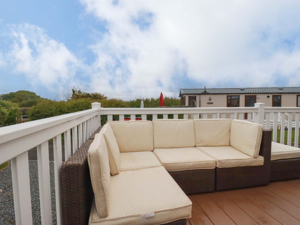 A sofa on a deck overlooking grass and buildings at CC2