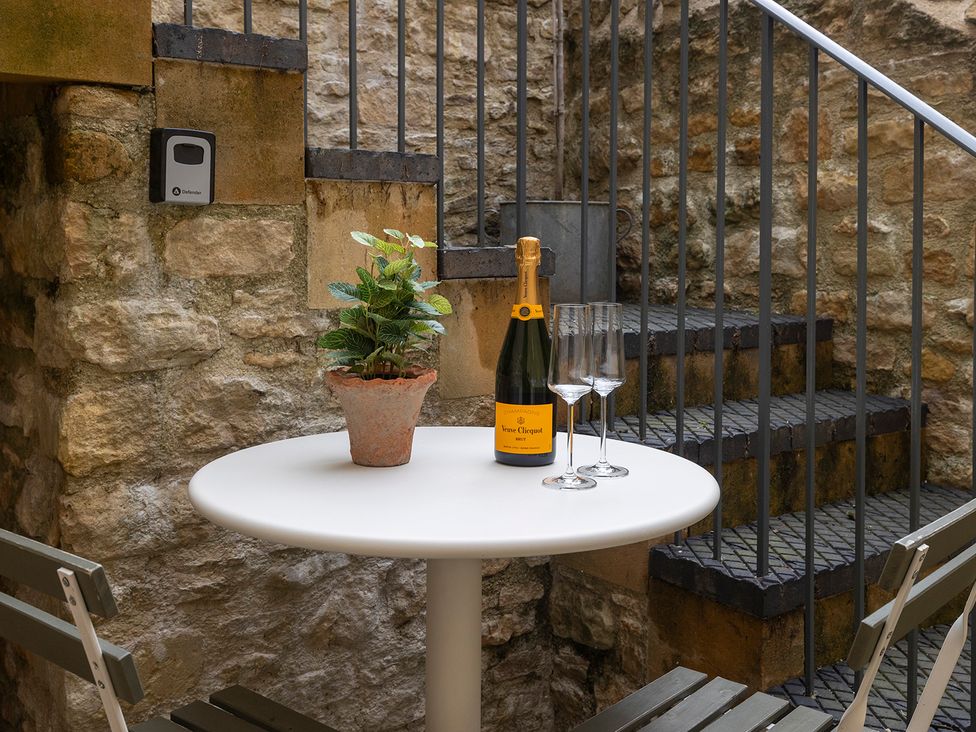 A table with champagne and glasses in an outdoor area at Church Alley House Stow-On-The-Wold