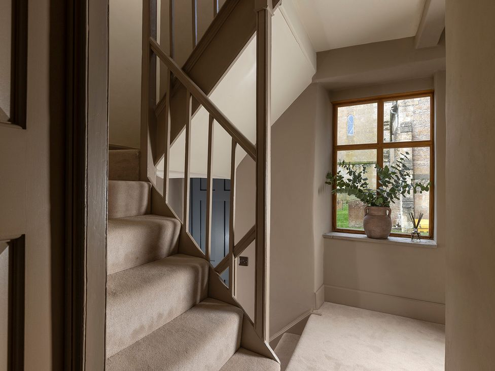 A hallway with stairs and a window at Church Alley House in Stow-On-The-Wold