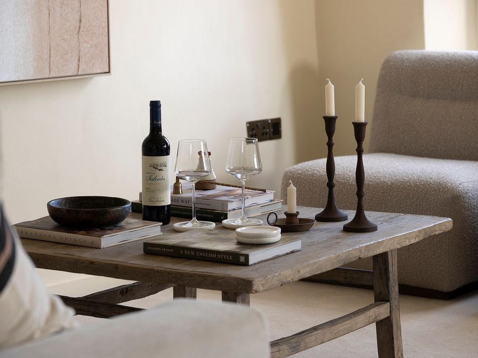 A living room with a coffee table featuring wine and candles at Church Alley House, Stow-On-The-Wold