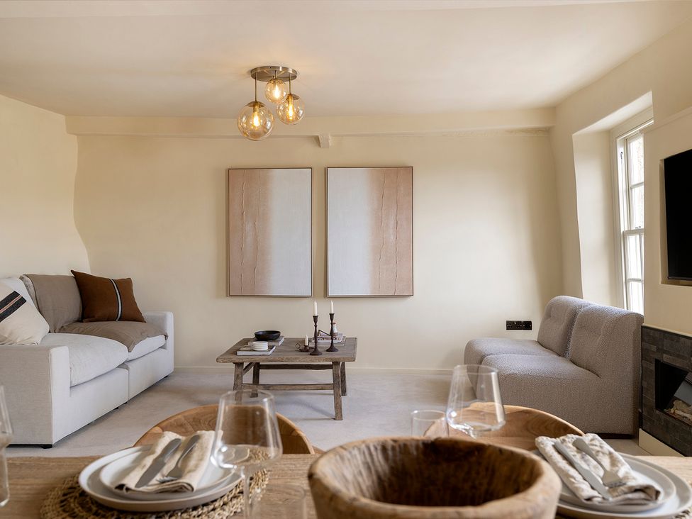 A living room with a sofa and table at Church Alley House Stow-On-The-Wold