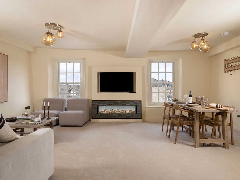 A living room with a sofa and dining table at Church Alley House in Stow-On-The-Wold
