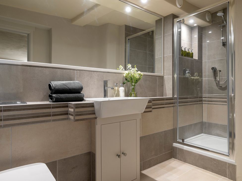 A bathroom featuring a sink, mirror, shower and towels at Church Alley House Stow-On-The-Wold