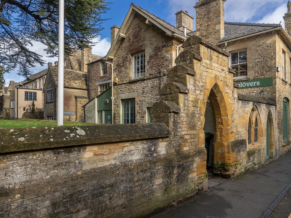 A street view of buildings and an archway at Church Alley House Stow-On-The-Wold