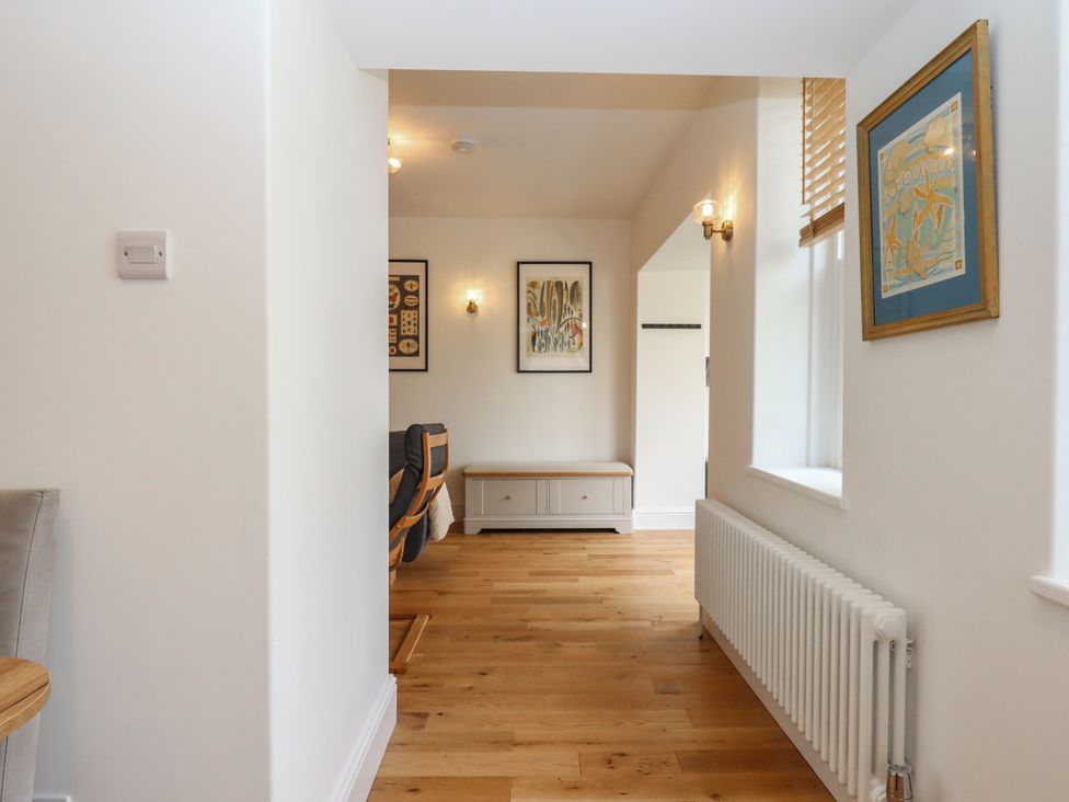 A hallway with artworks on the walls at Hares Cottage in Torquay