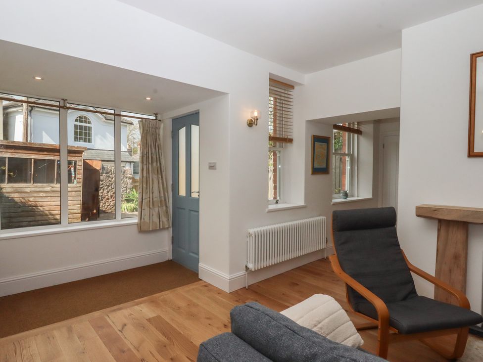 A living room with a chair and a window at Hares Cottage in Torquay