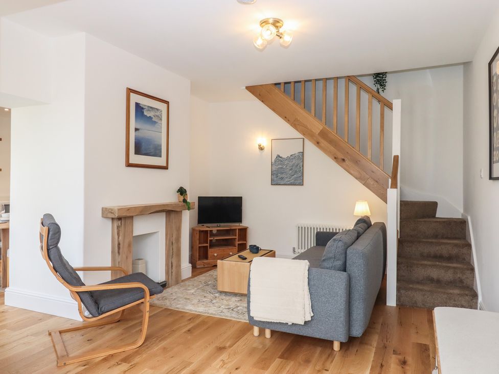 A living room with a sofa and television at Hares Cottage in Torquay