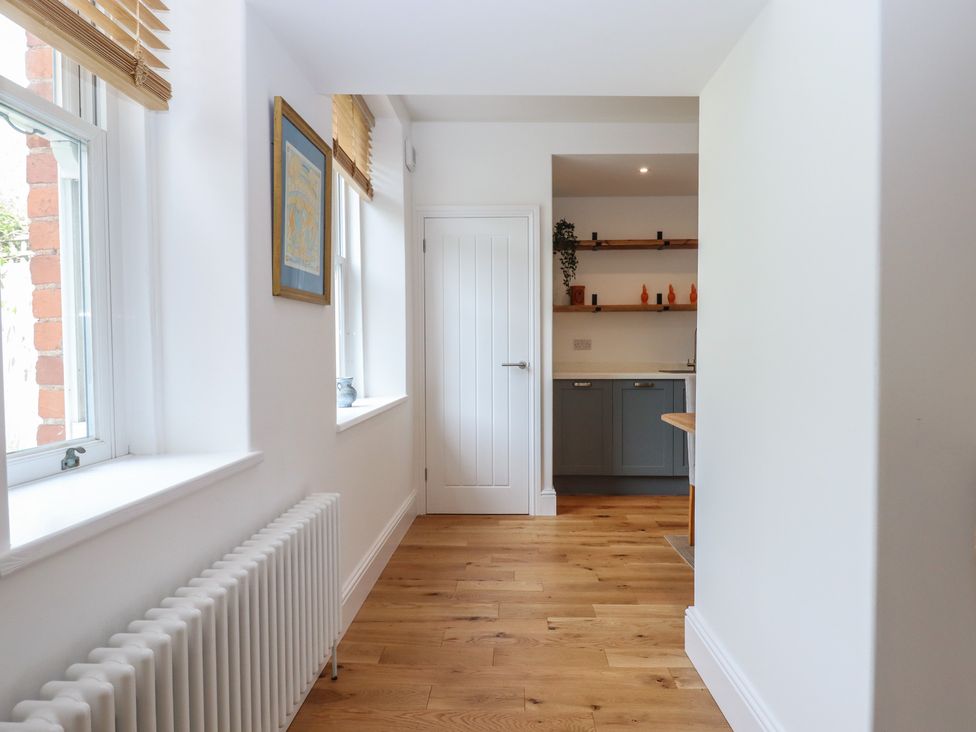 A hallway with windows and a door at Hares Cottage in Torquay