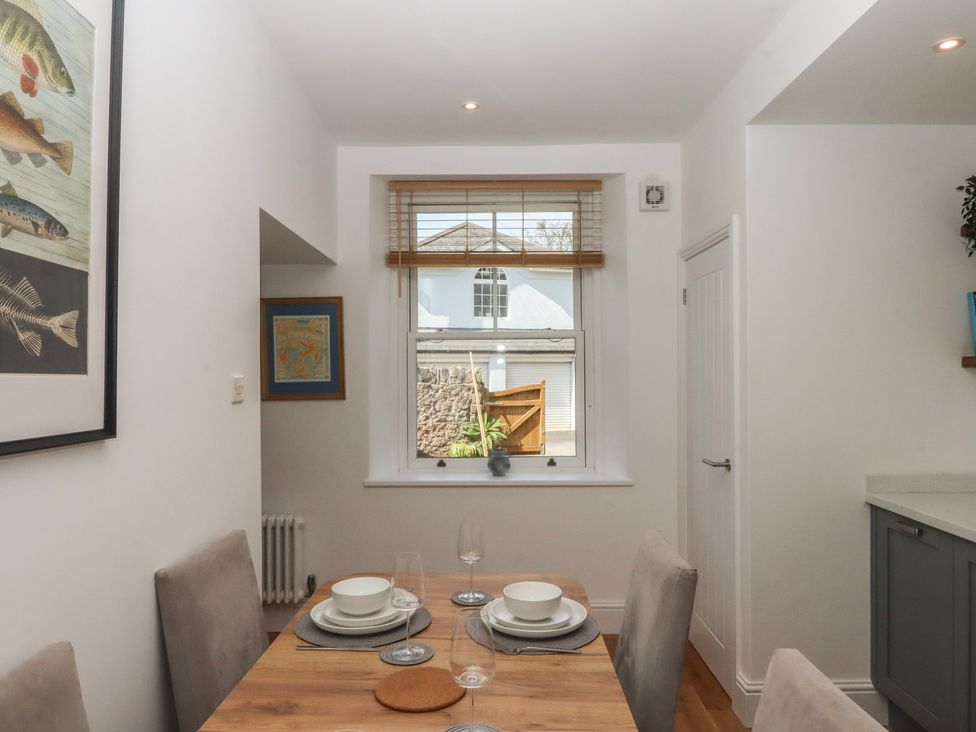 A dining room with a table set for meals at Hares Cottage in Torquay