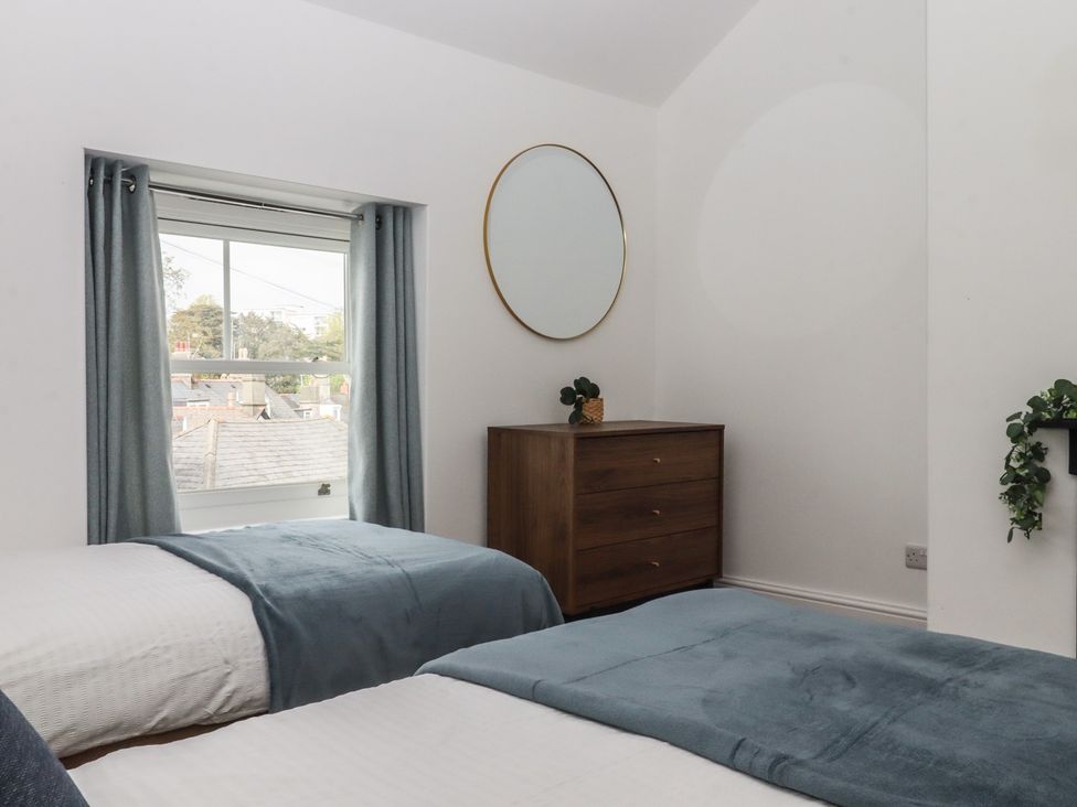 A bedroom with two beds and a dresser at Hares Cottage in Torquay