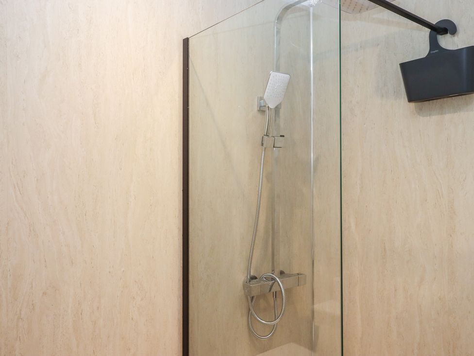 A shower area with glass wall at Hares Cottage in Torquay