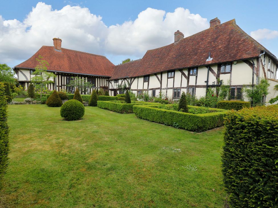A house with a garden and hedges at Dukes Place 