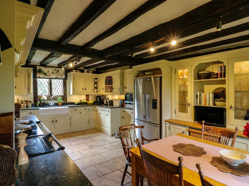 A kitchen with a stove, sink, and dining table at Dukes Place