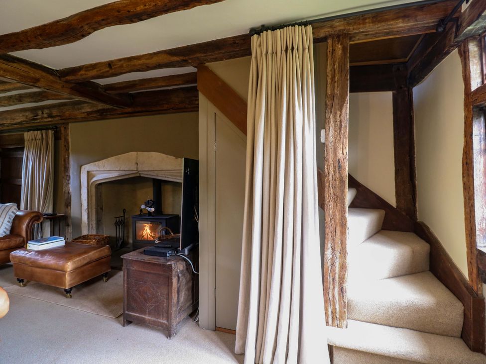A living room with a fireplace and staircase at Dukes Place