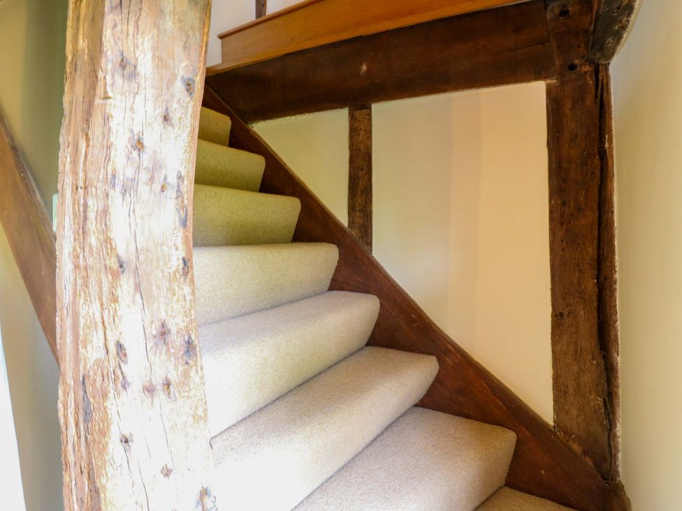 A staircase with carpet and wooden beams at Dukes Place