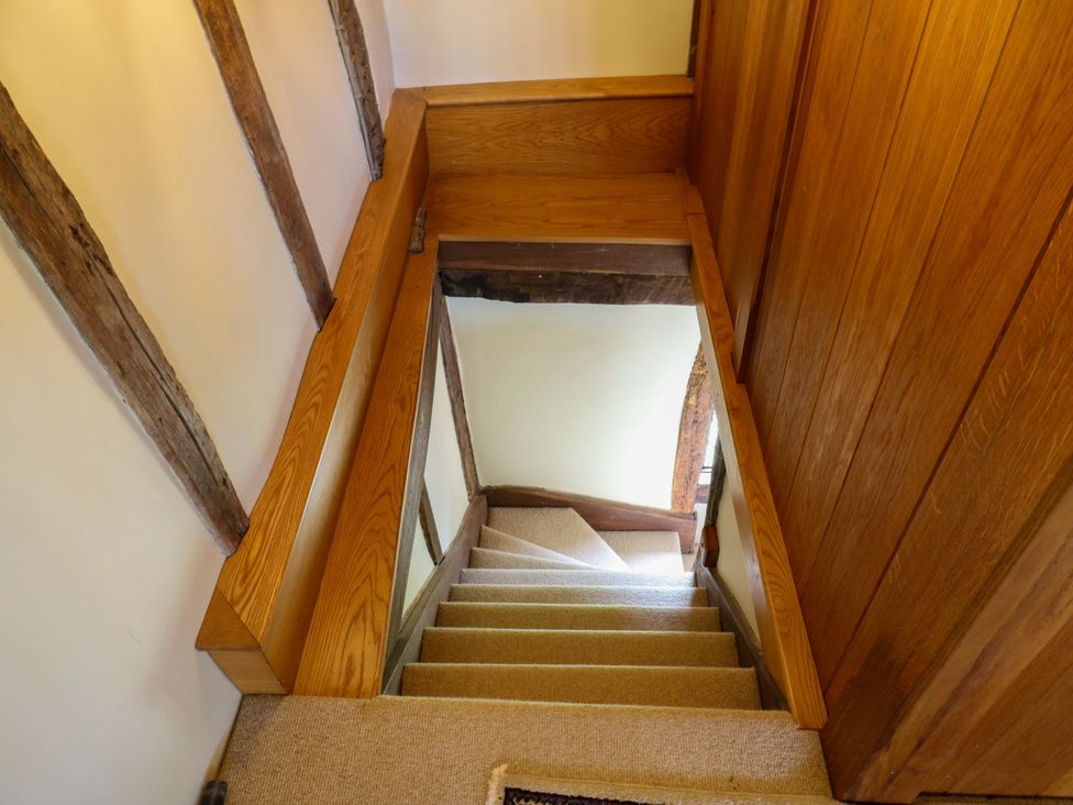 A staircase with a wooden handrail and carpet at Dukes Place