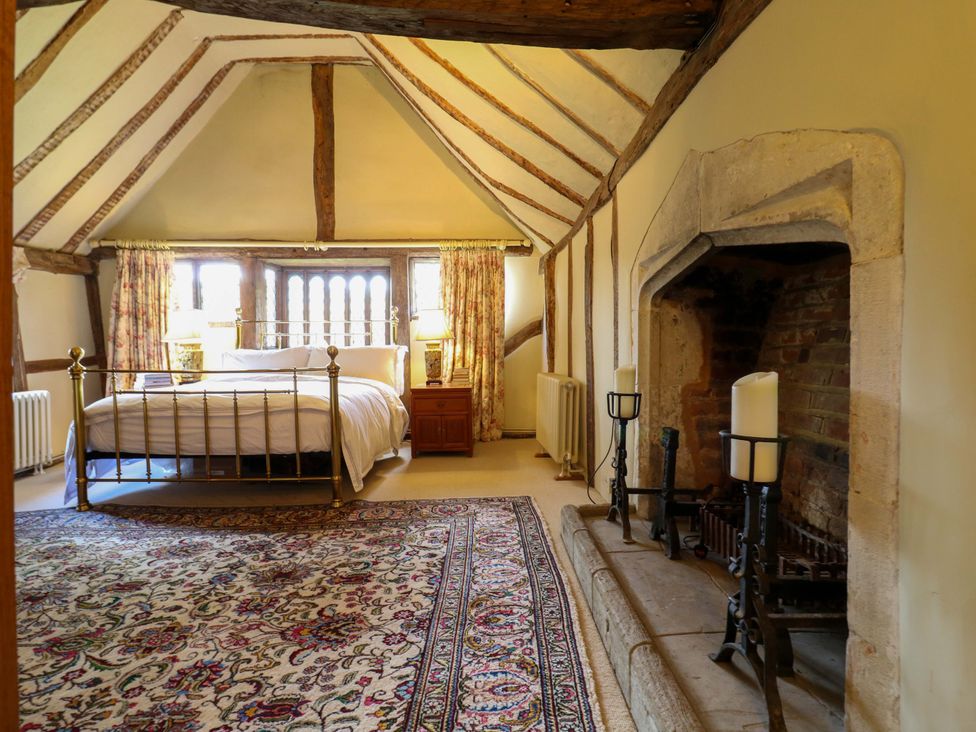 A bedroom with a bed, fireplace, and window at Dukes Place