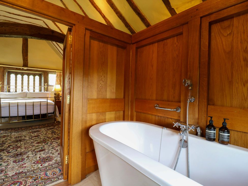 A bathroom with a bathtub and wooden decor at Dukes Place