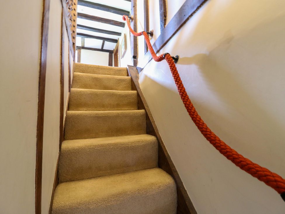 A staircase with carpet and wooden railing at Dukes Place