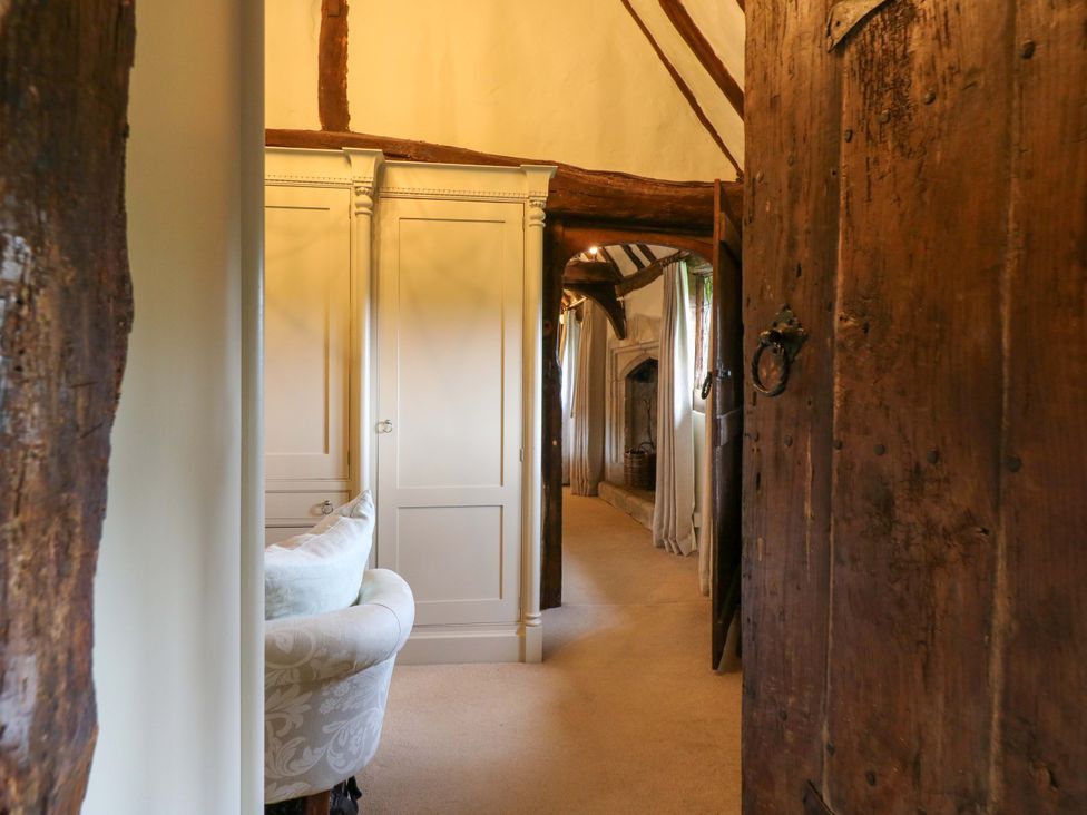 A hallway with a wooden door and an armoire at Dukes Place
