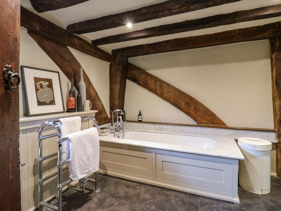 A bathroom with a bathtub and a towel rack at Dukes Place 
