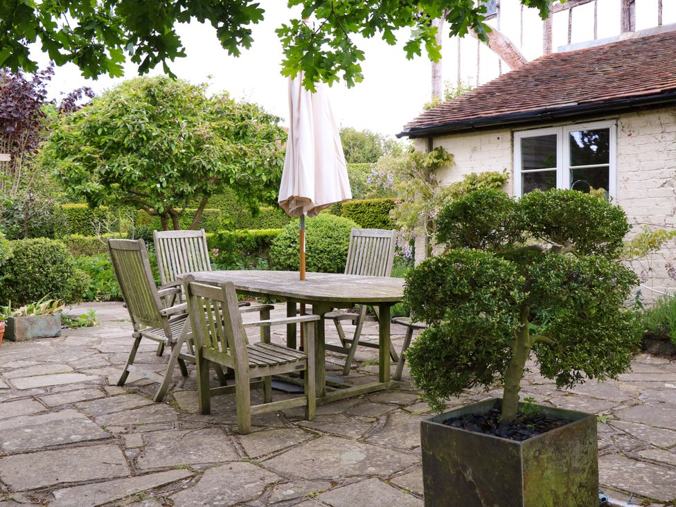 A garden with a wooden table and chairs at Dukes Place in 