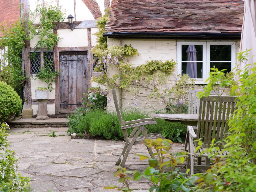 A garden with a stone pathway and wooden table and chairs at Dukes Place 