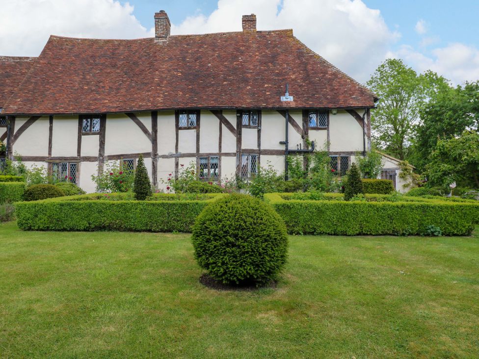 A garden with a building and hedges at Dukes Place 