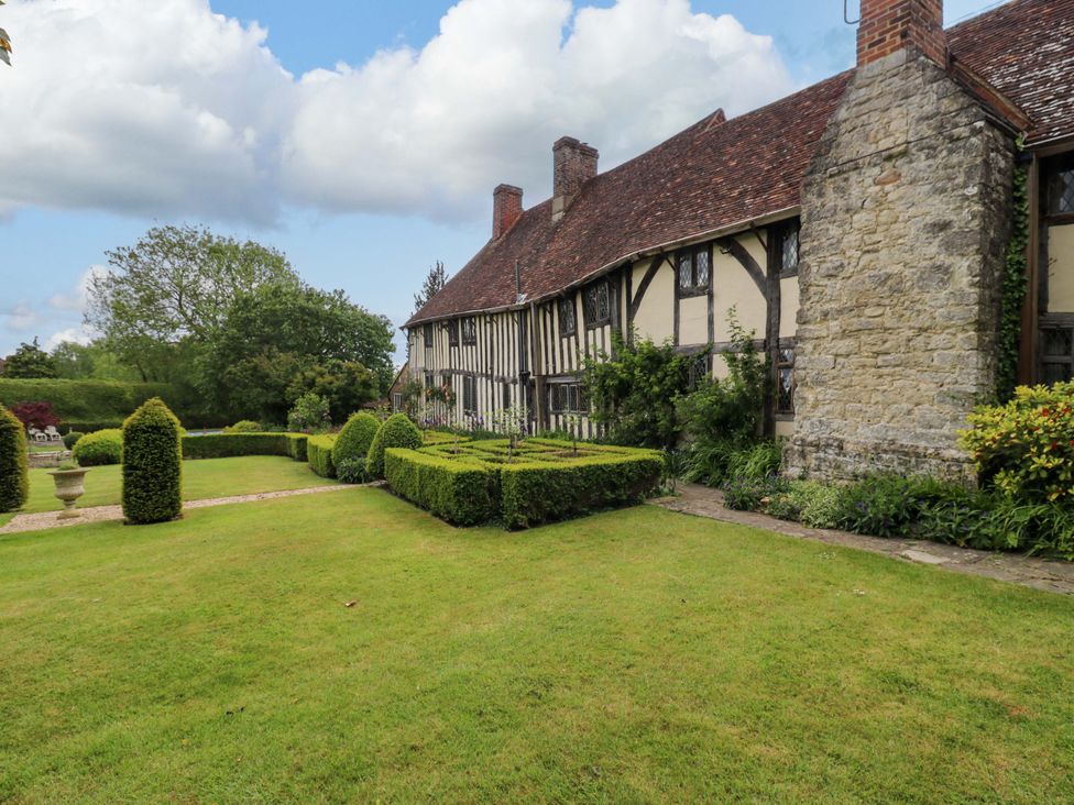 A garden with a house and hedges at Dukes Place