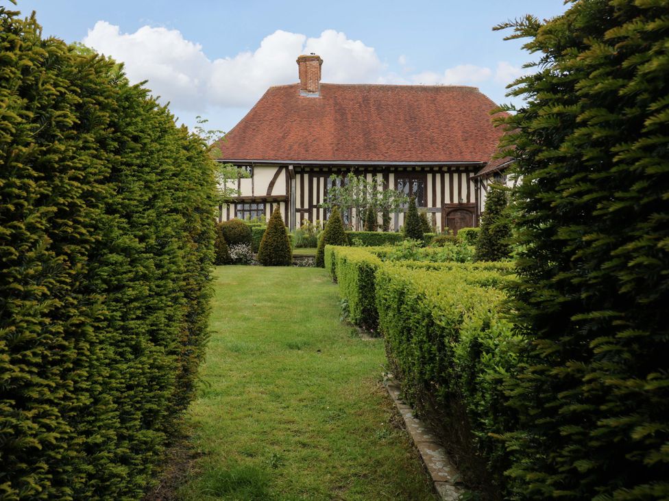 A house surrounded by hedges and a path in the garden at Dukes Place
