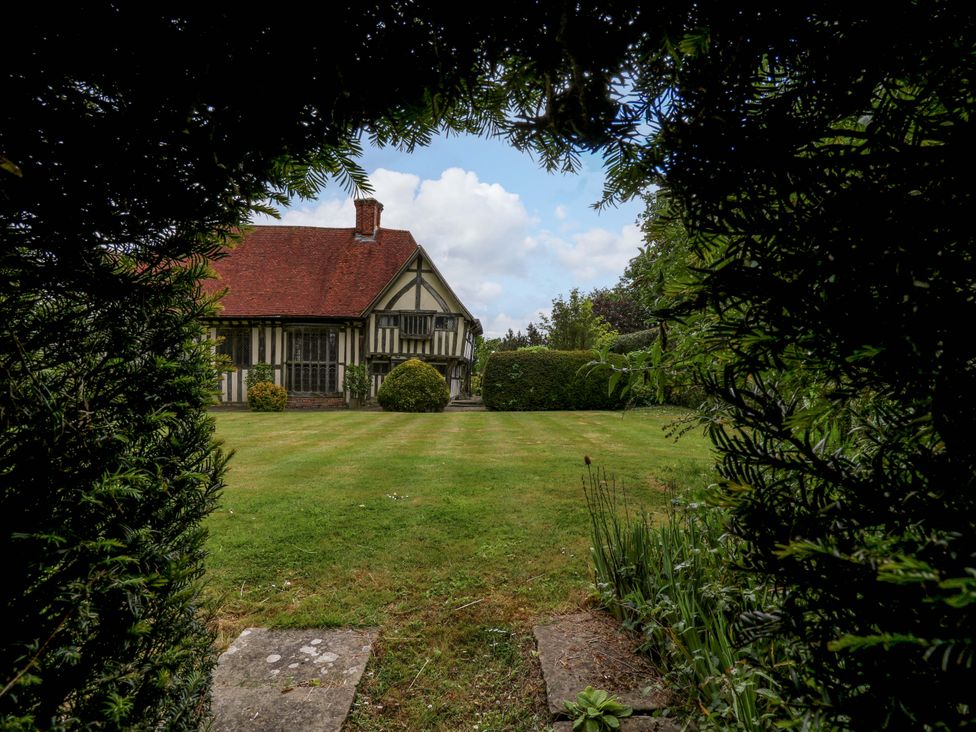 A house with a garden viewed through hedges at Dukes Place 