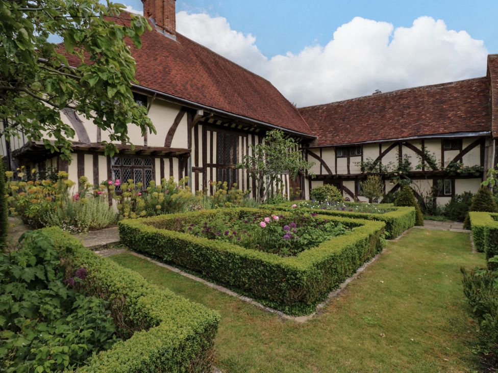A garden with flower beds and a house at Dukes Place