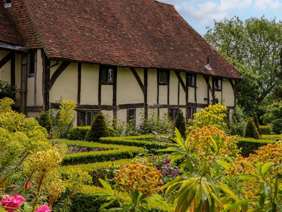 A house and garden with flowers and hedges at Dukes Place