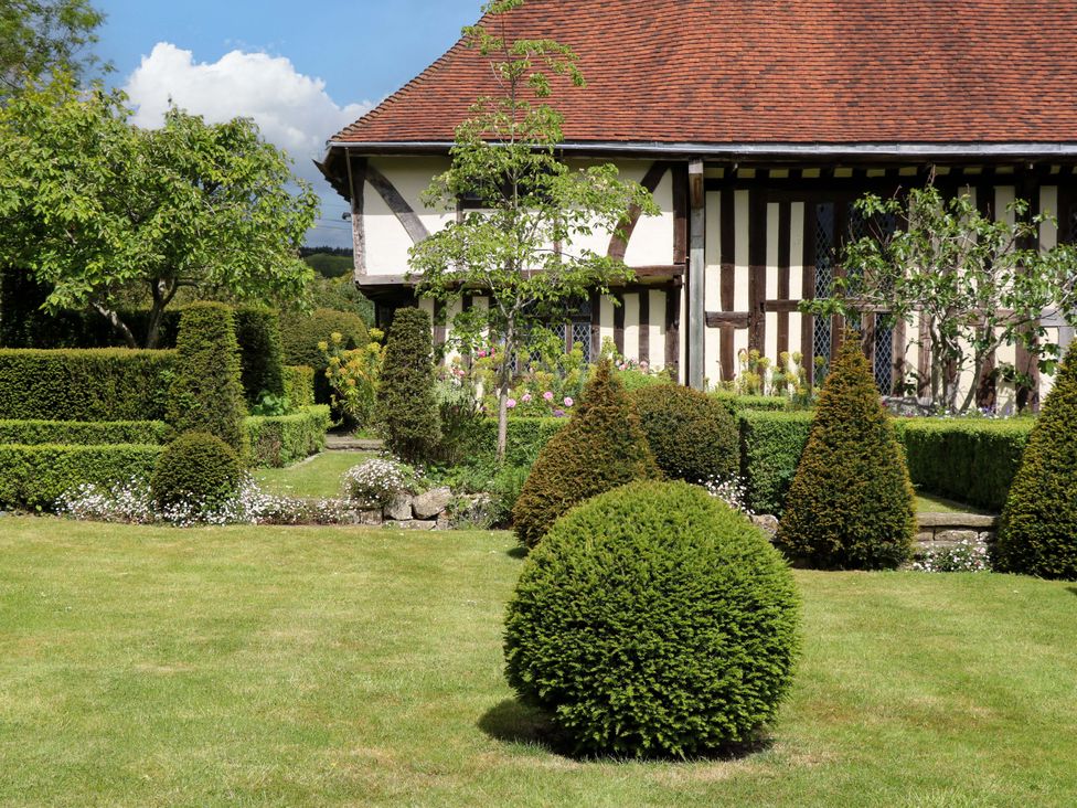 A garden with neatly trimmed bushes and a house in Dukes Place