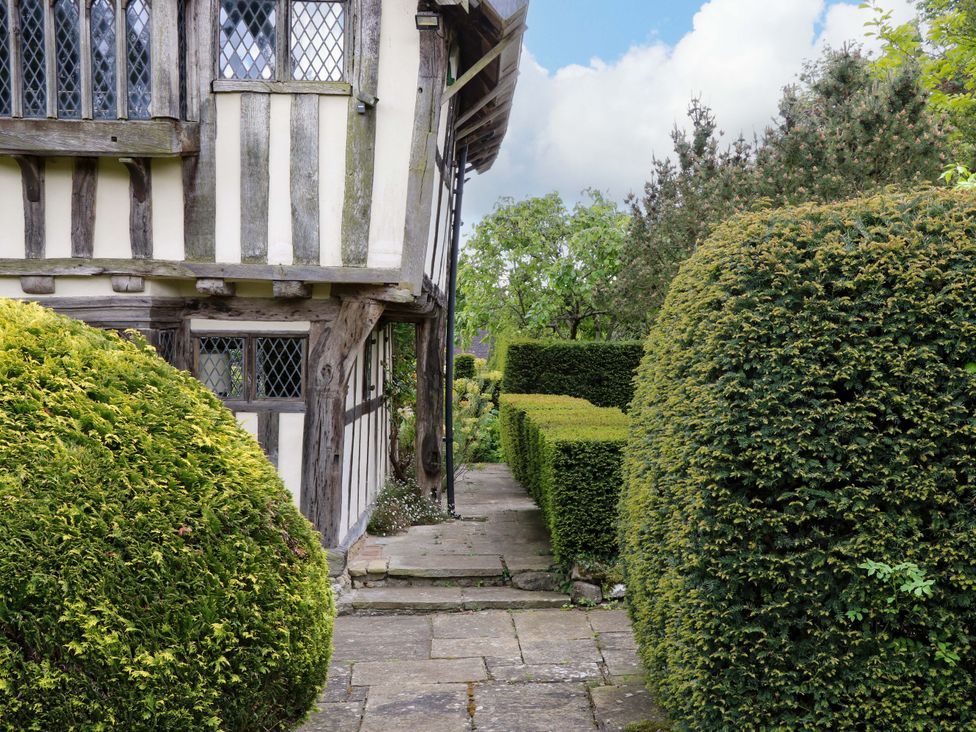 A garden with bushes and a pathway adjacent to a house at Dukes Place