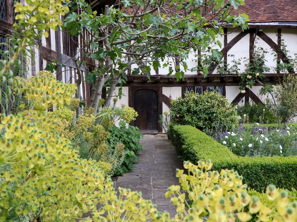 A garden with a path leading to a wooden door at Dukes Place
