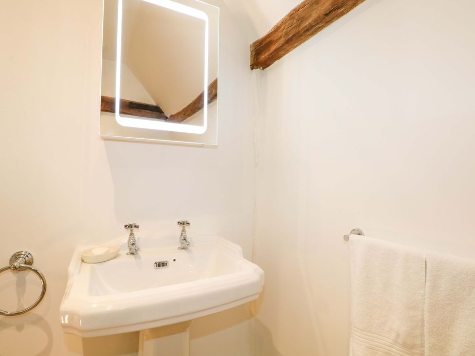 A bathroom with a sink and mirror at The Granary in Petworth