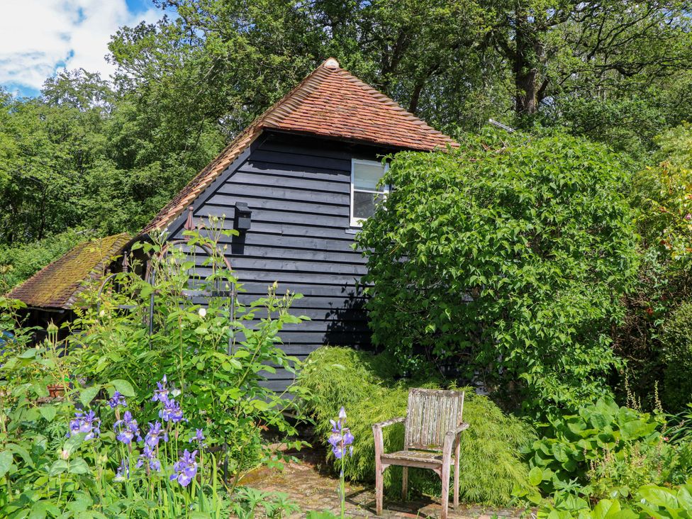 A house with a chair and flowers in the garden at The Granary, Petworth