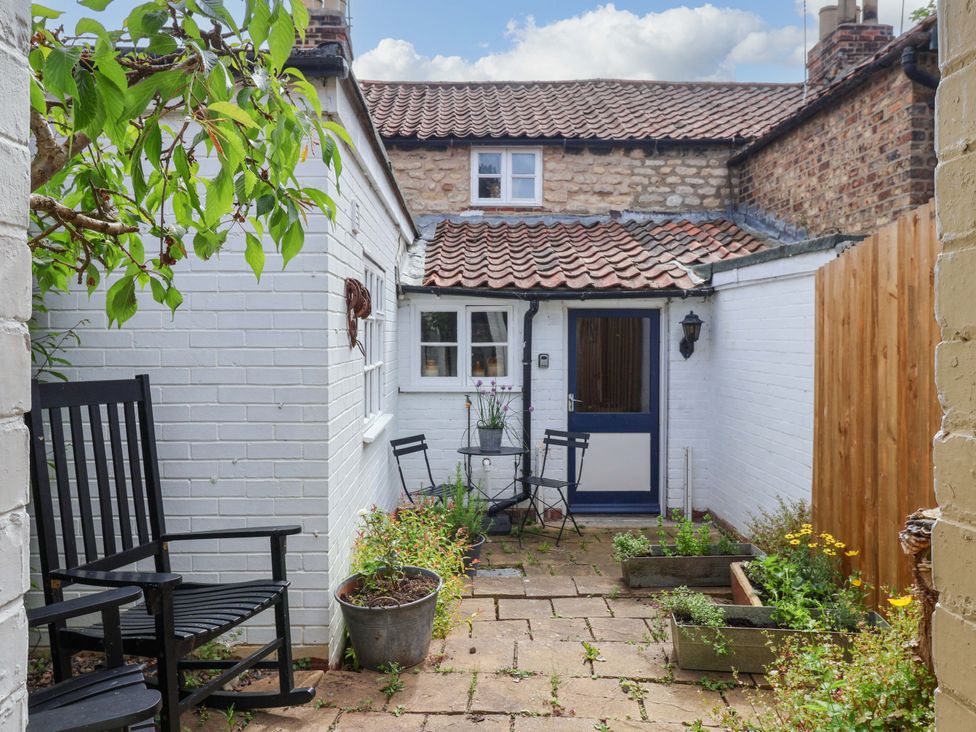 A garden with a table and chairs at The Cook’s Cottage in Malton